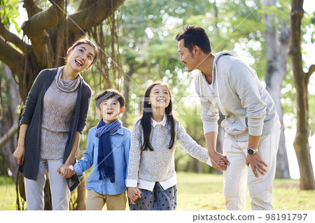 asian family with two children having fun exploring woods in a park 98191797