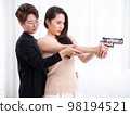 Young Asia LGBT teaches her girlfriend the backslider how to handle a weapon, firearm training at a firing range, in the bedroom 98194521