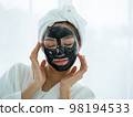 Portrait of Young woman relaxing with facial masks on white background 98194533