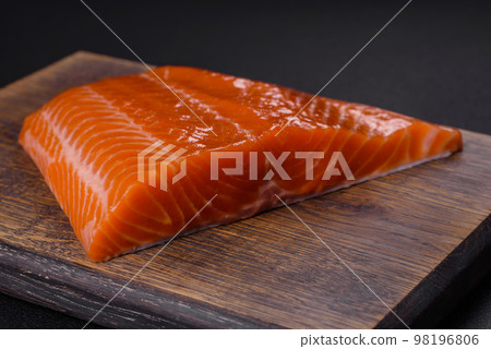 Fillet of raw red salmon fish with salt, spices and herbs 98196806