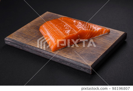 Fillet of raw red salmon fish with salt, spices and herbs 98196807