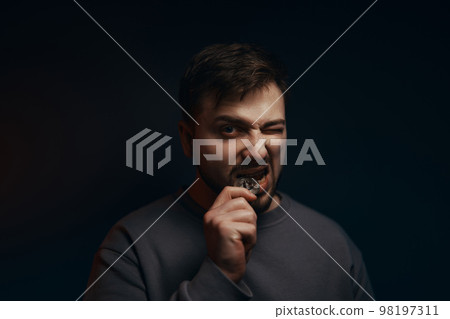 A young man with a bitcoin in his hands. Cryptocurrency. 98197311