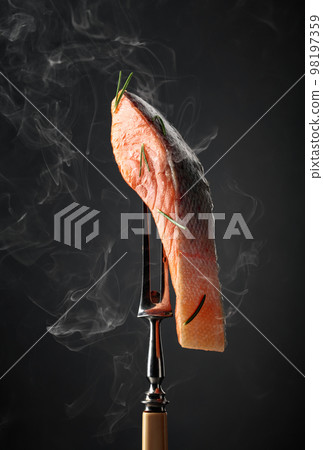 Smocked salmon with rosemary on a fork. Smocked salmon with rosemary on a fork. 98197359