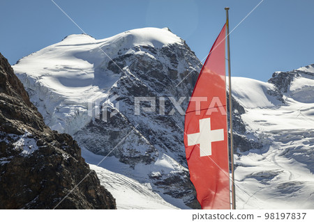 Swiss flag and Bernina mountain range with glaciers in the Alps, Switzerland Swiss flag and Bernina mountain range with glaciers in the Alps, Switzerland 98197837