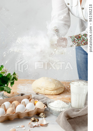 Female Hands Clapping Making Flour Splash above the Dough Female Hands Clapping Making Flour Splash above the Dough 98198218
