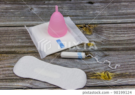 Sanitary pad, tampons and menstrual cup on wooden background. Concept of critical days, menstruation, feminine hygiene 98199124