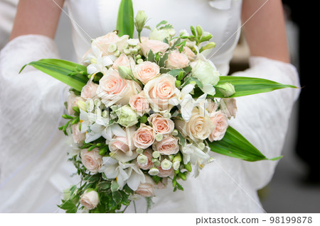 An image of a bride holding her bouquet of roses An image of a bride holding her bouquet of roses 98199878