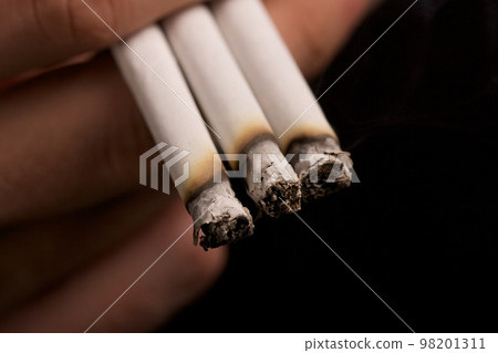 smoker holding three cigarettes 98201311