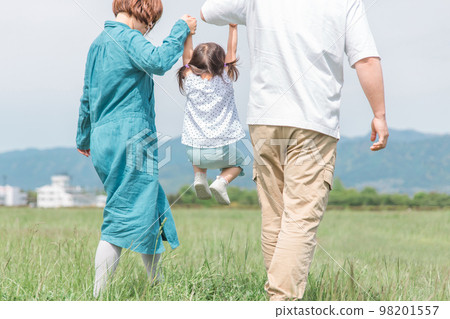 家庭、父母和孩子，一家人手牽著手在公園裡散步和跳躍的背影（孩子、父母、旅行） 98201557