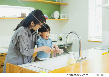 Child and mother washing hands in the kitchen 98201868