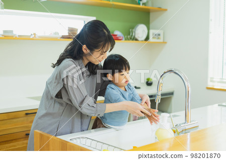 Child and mother washing hands in the kitchen 98201870