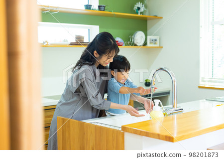 Child and mother washing hands in the kitchen 98201873