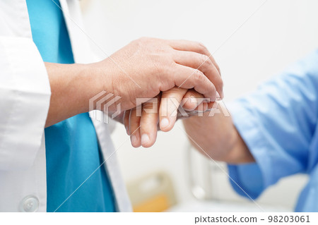 Doctor holding hands Asian elderly woman patient, help and care in hospital. 98203061