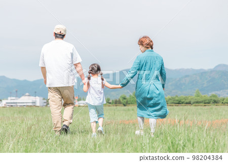 Back view of family/family walking in park/grassland in spring/summer (children/parents/migration/country life) 98204384