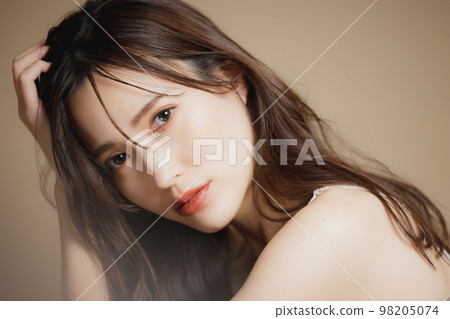 A woman in a beige dress A woman in a beige dress 98205074