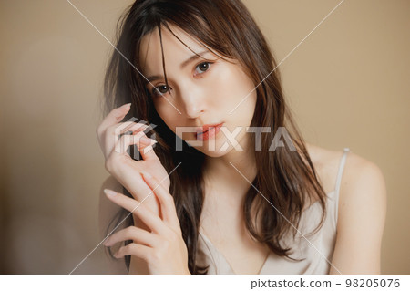 A woman in a beige dress A woman in a beige dress 98205076
