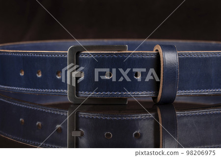Part of a blue leather belt on a black background. 98206975