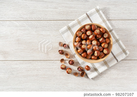 hazelnut in wooden bowl on white table with copy space. Top view hazelnut in wooden bowl on white table with copy space. Top view 98207107