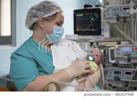 Nurse with a baby in intensive care. Newborn baby in the hospital. 98207496
