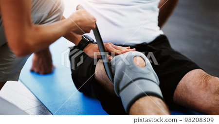 Rehabilitation, woman therapist or knee brace in physiotherapy with senior man patient, knee pain or consulting expert. Physiotherapist, physical therapy and healthcare worker help, support or advice 98208309