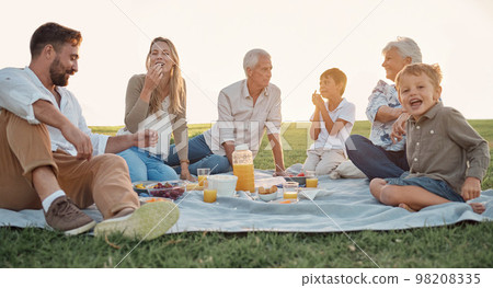 Love, picnic and family happiness with people smile and relax at a park or field, bonding and having fun. Happy kids enjoy weekend holiday with grandparents and parents, love and food in Germany 98208335