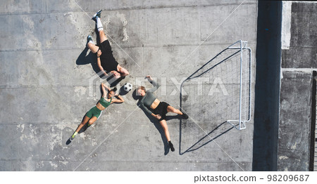 Top view, soccer ball and friends relax on rooftop together after practice. Football, sports team and man, women and break after exercise match, workout or intense training session on roof in city. Top view, soccer ball and friends relax on rooftop together after practice. Football, sports team and man, women and break after exercise match, workout or intense training session on roof in city. 98209687