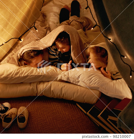 Were never going to sleep. three young children playing in a tent together. 98210007