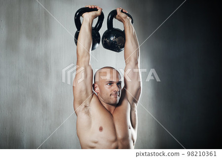 Weights and willpower. a man working out with kettle bells at the gym. Weights and willpower. a man working out with kettle bells at the gym. 98210361