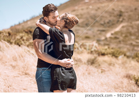 Kissing, relaxed and romantic couple enjoying love, bonding and break on getaway together on a sunny day outdoors. Boyfriend and girlfriend in a loving relationship on honeymoon, holiday and date Kissing, relaxed and romantic couple enjoying love, bonding and break on getaway together on a sunny day outdoors. Boyfriend and girlfriend in a loving relationship on honeymoon, holiday and date 98210413