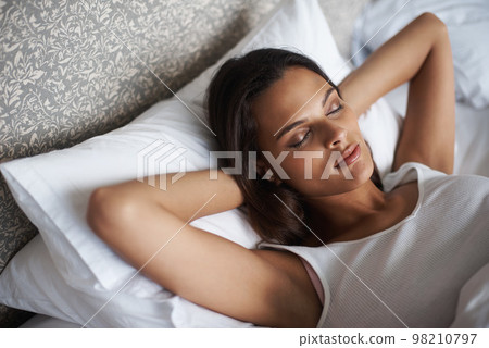 Shes sound asleep. A beautiful young woman sleeping in her bed. Shes sound asleep. A beautiful young woman sleeping in her bed. 98210797