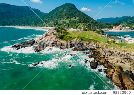 Coastline with rocks, mountains, beach and stormy ocean in Brazil. Aerial view of Matadeiro beach and Ponta das Campanhas 98210960