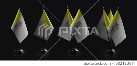 Small national flags of the Vatican on a black background 98211397
