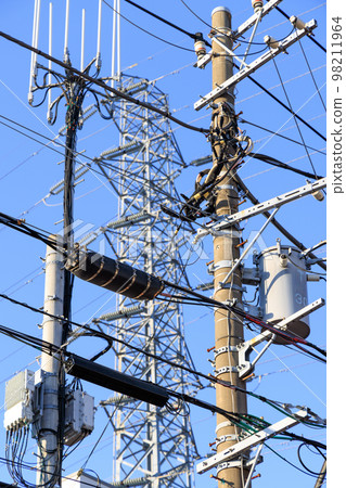 Sky crowded with utility poles, steel towers and wires 98211964