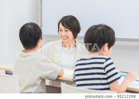 A smiling female cram school teacher / teacher who teaches elementary school students (study cram school, summer course, Asian) 98212298