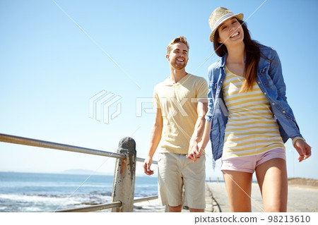 Love, beach and portrait of couple holding hands at the beach for travel, fun and summer vacation. Sea, holiday and young man with woman bond while walking, happy and smile while relaxing in Florida Love, beach and portrait of couple holding hands at the beach for travel, fun and summer vacation. Sea, holiday and young man with woman bond while walking, happy and smile while relaxing in Florida 98213610