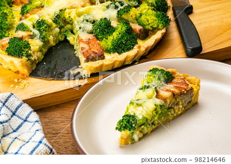 Broccoli and salmon quiche on cutting board. 98214646