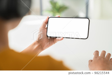 Hand holding digital smartphone mockup of blank screen. Take your screen to put on advertising. 98215544