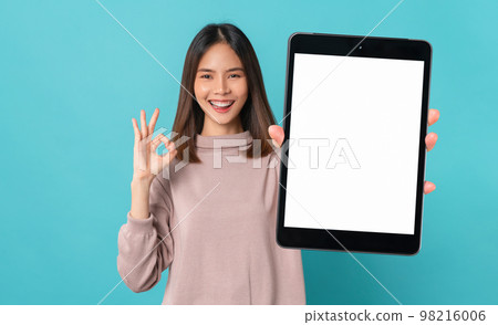 Beautiful Asian woman holding smartphone mockup of blank screen and shows ok sign on blue background Beautiful Asian woman holding smartphone mockup of blank screen and shows ok sign on blue background 98216006