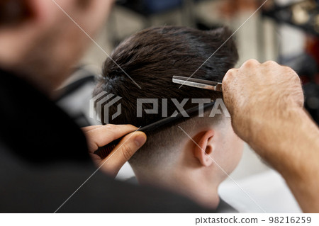 Professional hairdresser does haircut for caucasian bearded man Professional hairdresser does haircut for caucasian bearded man 98216259