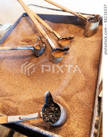 Preparation of natural coffee in Turks on the sand. 98216337