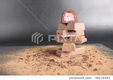 Three chocolate couscous lie on the cocoa on a black grey background with room for a copy of the chocolate brown chocolate table Three chocolate couscous lie on the cocoa on a black grey background with room for a copy of the chocolate brown chocolate table 98216465