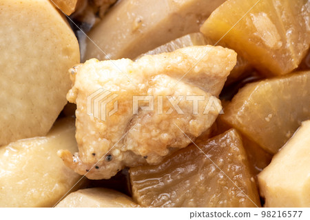 Simmered sweet potato, daikon radish, and chicken, with a focus on chicken. 98216577