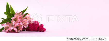 Composition of purple flowers Alstroemeria with a knitted pink hearts on a pink background. Valentine's Day concept, greetings for a loved one, top view, banner Composition of purple flowers Alstroemeria with a knitted pink hearts on a pink background. Valentine's Day concept, greetings for a loved one, top view, banner 98216674