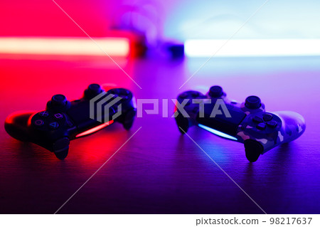 Gamepad on a wooden table with backlight. 98217637