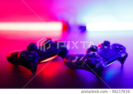 Gamepad on a wooden table with backlight. 98217638