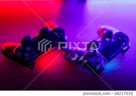 Gamepad on a wooden table with backlight. Gamepad on a wooden table with backlight. 98217639