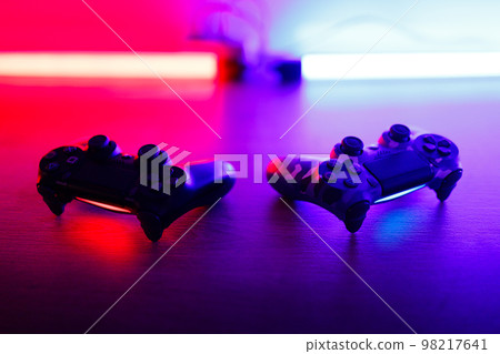 Gamepad on a wooden table with backlight. Gamepad on a wooden table with backlight. 98217641