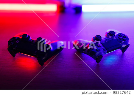 Gamepad on a wooden table with backlight. 98217642