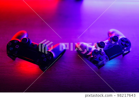Gamepad on a wooden table with backlight. 98217643