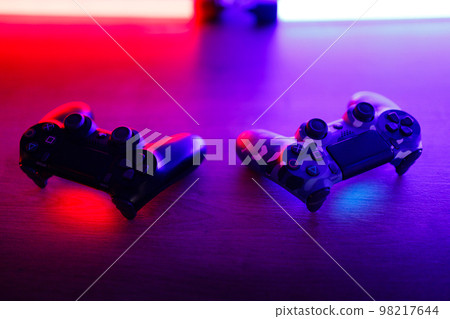Gamepad on a wooden table with backlight. 98217644